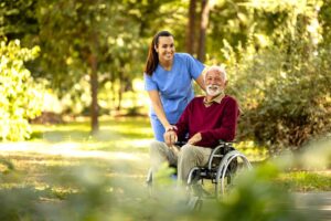 A caregiver and an older adult reviewing a care plan together at a kitchen table, both appearing focused and engaged.